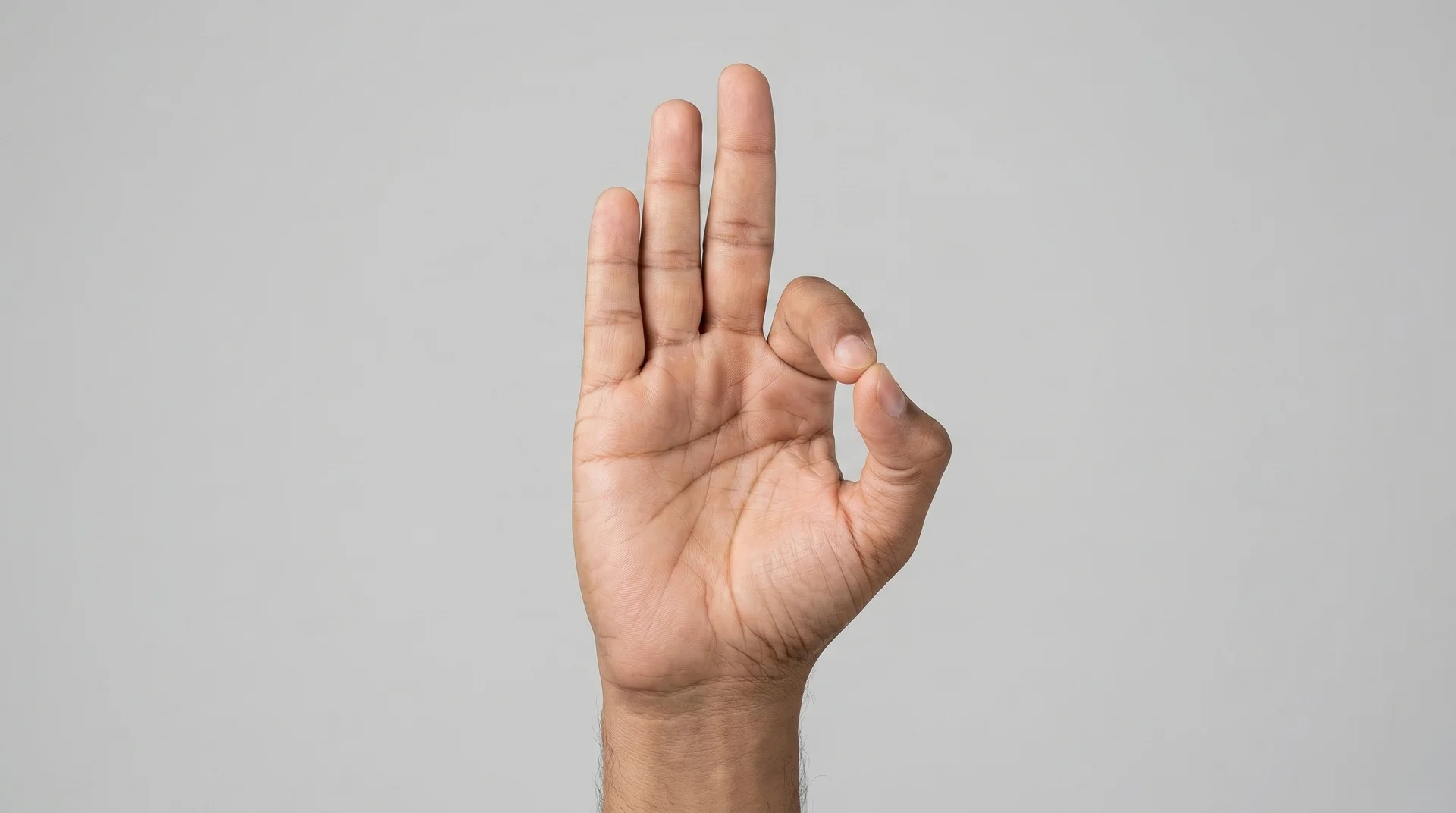 Close-up of a person's hand performing the Gyan mudra gesture, with the tips of the thumb and index finger touching to form a circle.