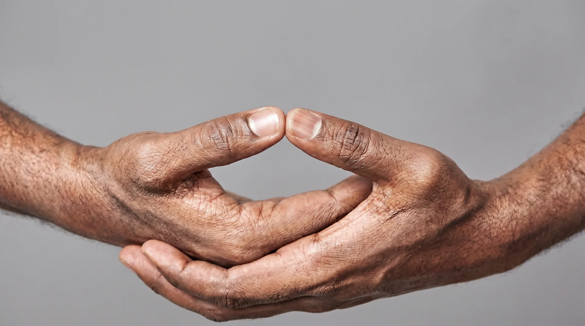 Close-up of a person's hands resting in their lap forming the Dhyana Mudra gesture, with palms facing up and thumbs touching.
