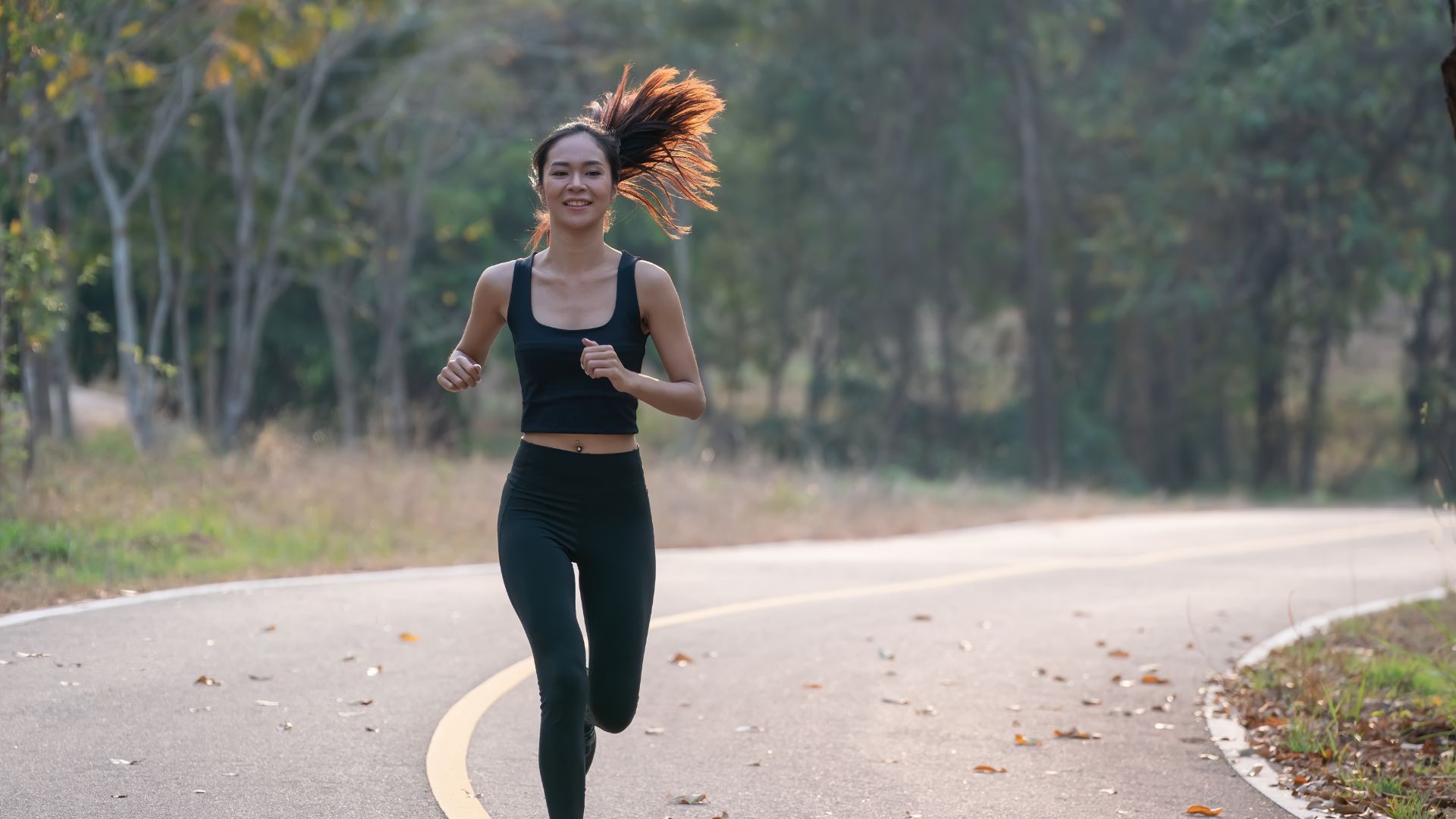 Beginner runner jogging outdoors on a quiet road, showing how to start running for beginners with a simple fitness routine.